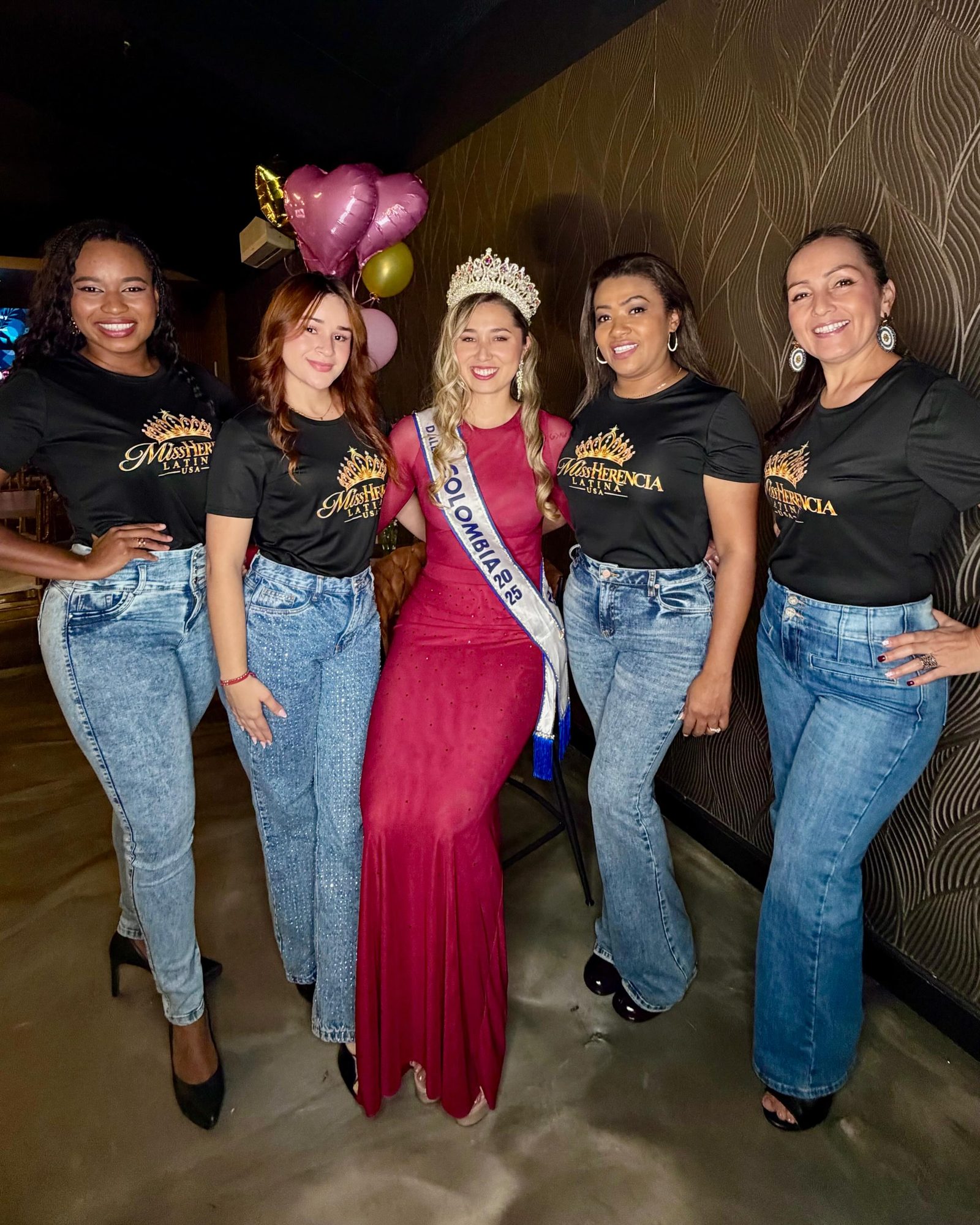 El equipo de Miss Herencia Latina USA, con camisetas de la marca, junto a la reina 2025